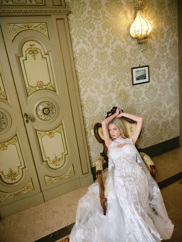 Amante bridal gown shown seated, highlighting the elongated lace silhouette and soft flowing train