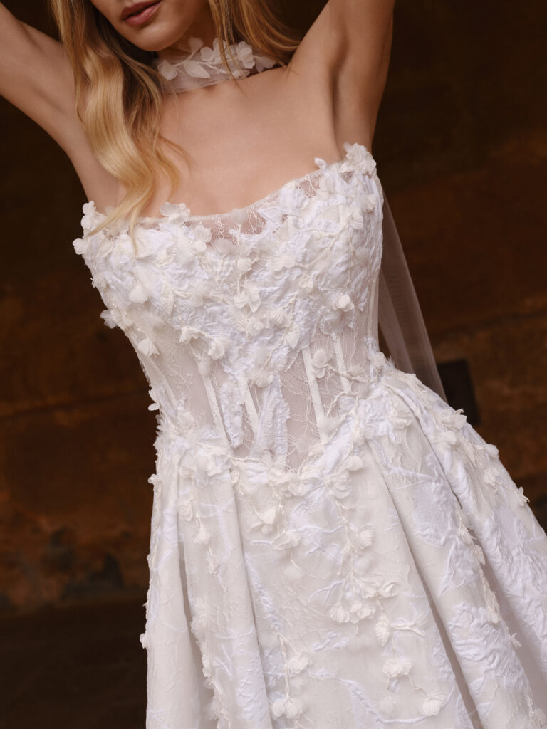 Close-up of the Mio Cuore bodice showing exposed boning, sheer construction and 3D floral appliqué