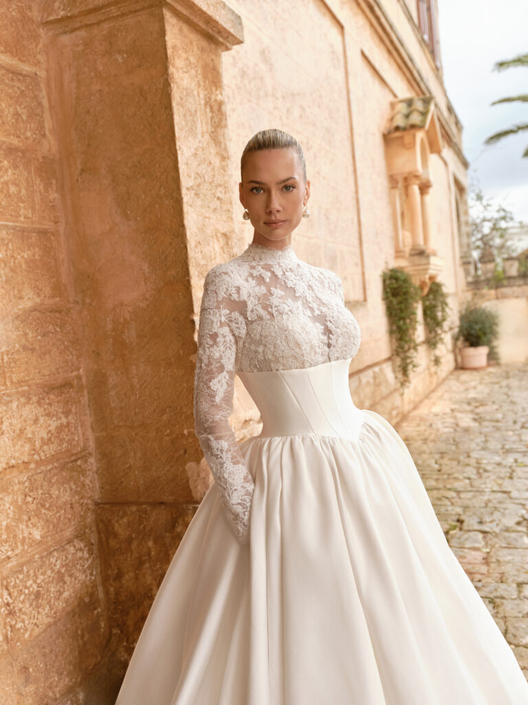 Carissima wedding dress front view with embellished lace bodice, high neckline and structured satin skirt