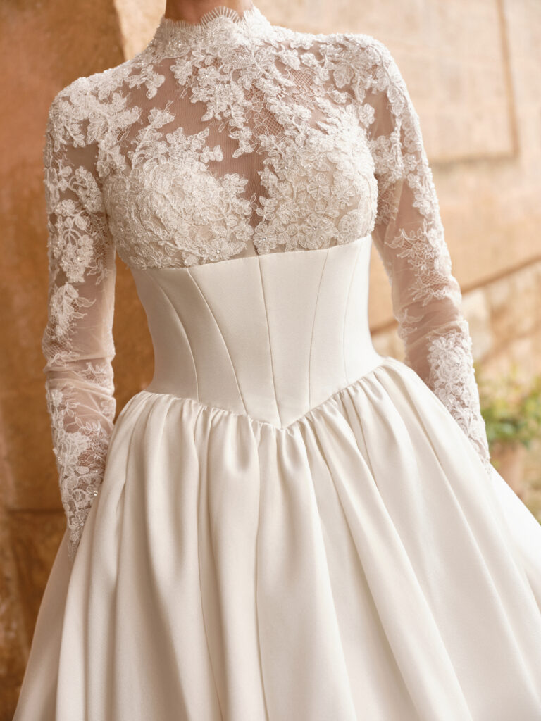 Carissima wedding dress close-up showing lace bodice, long sleeves and satin waist section