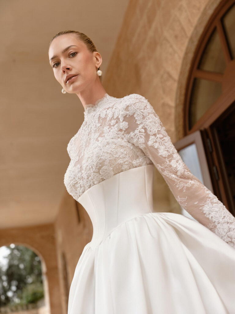 Carissima bridal gown side view showing high-neck lace bodice and structured satin skirt