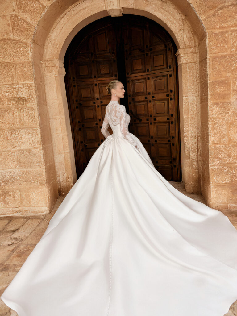 Carissima bridal gown back view showing full satin skirt, long train and button detailing