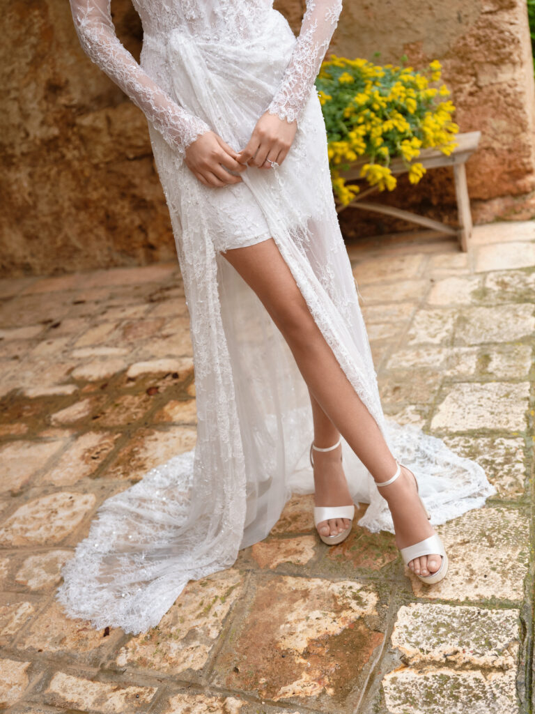 Amore Mio wedding dress showing sheer lace overskirt with high front split revealing fitted mini underneath