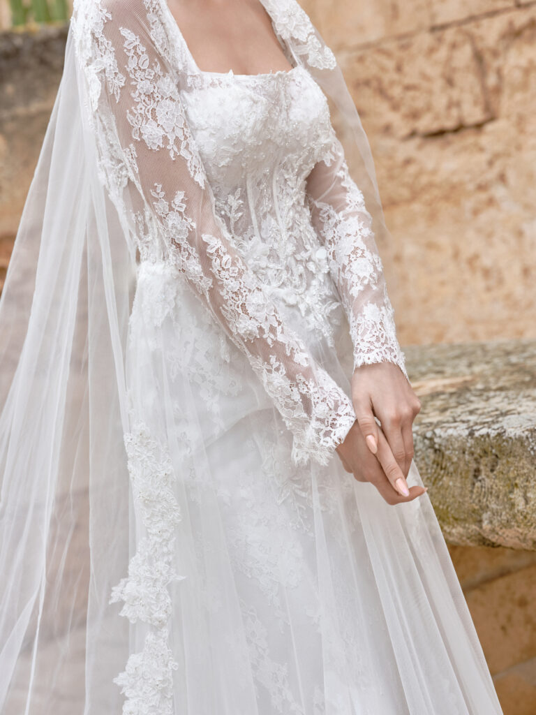Adora bridal gown detail showing detachable long sleeve lace strap and sheer fabric layers