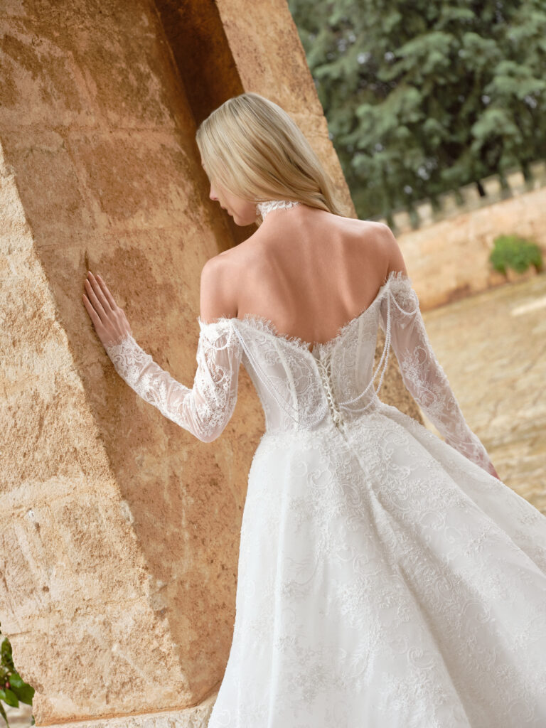 Amore Puro bridal gown angled back view showing off-shoulder sleeves and fitted waist