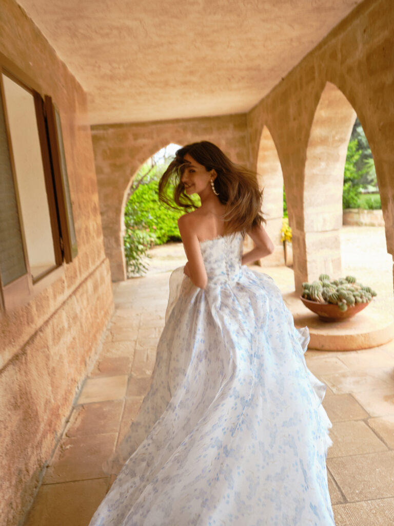 Azzura wedding dress back view showing flowing blue floral skirt and strapless bodice
