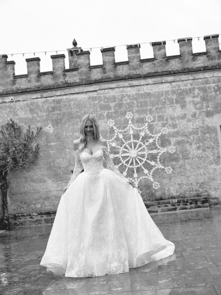 Stella Mia wedding dress full length showing off-the-shoulder lace sleeves and full A-line silhouette