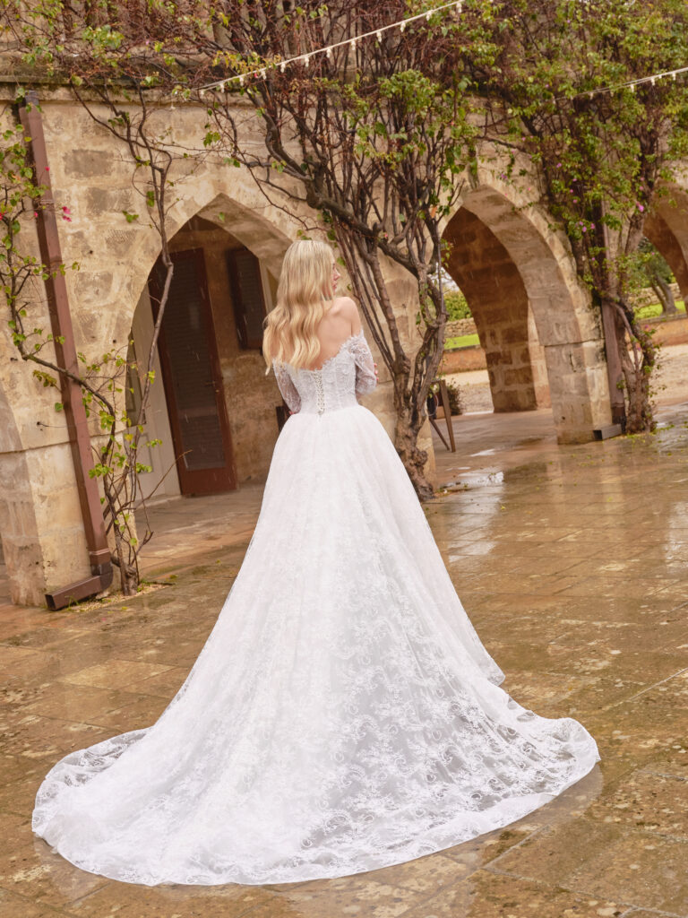 Stella Mia bridal gown back view showing lace sleeves, full A-line skirt and sweeping train